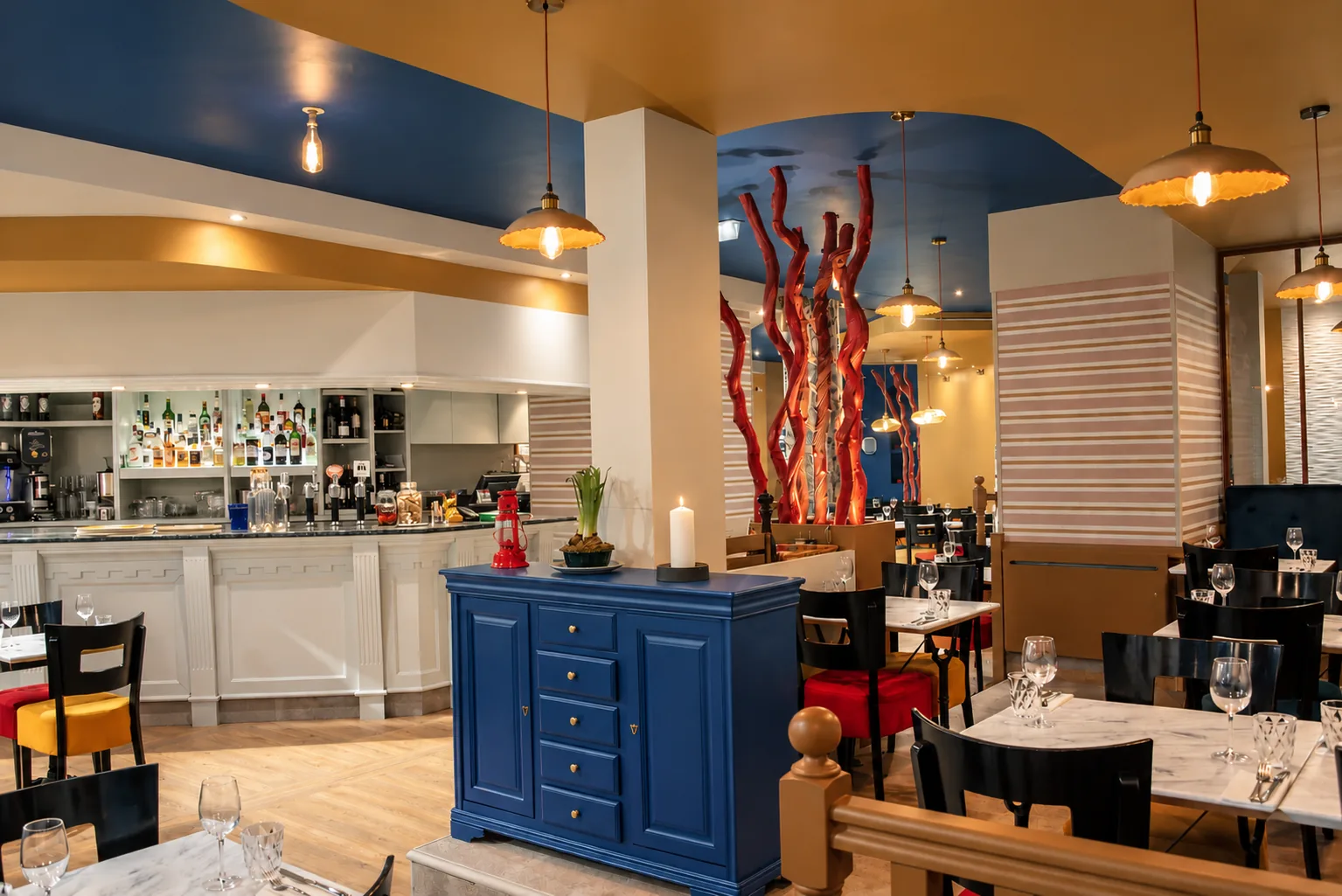 La grande salle et le bar, plafond bleu nuit, buffet bleu et suspensions dorées